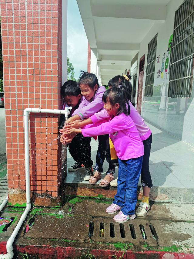 广西侨联及广西华侨爱心基金会为玉林市陆川县东西村小学打井，解决孩子健康安全饮水问题。图为孩子们在干净的水前露出了快乐的笑容.jpg